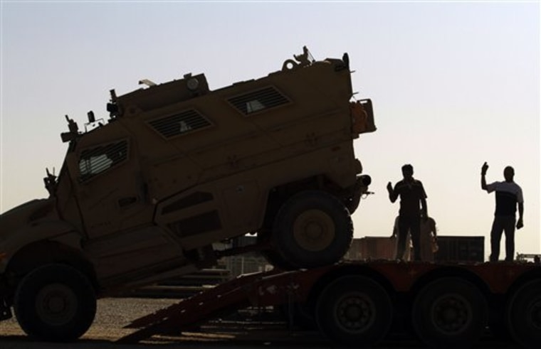 Iraqi truck drivers help guide a U.S. military mine-resistant armored vehicle (MRAP) onto a flatbed truck set to leave Iraq at a staging yard at Joint Base Balad, north of Baghdad, Iraq. Everything from helicopters to printer cartridges are being wrapped and stamped and shipped out of Iraq in one of the most monumental withdrawal operations the American military has ever carried out.